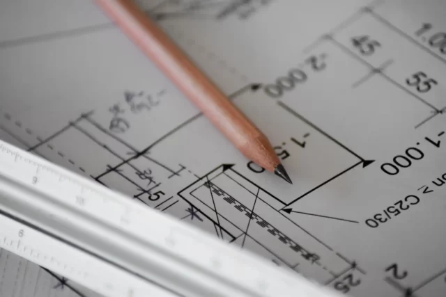 Socials Code drafting with a pencil on paper